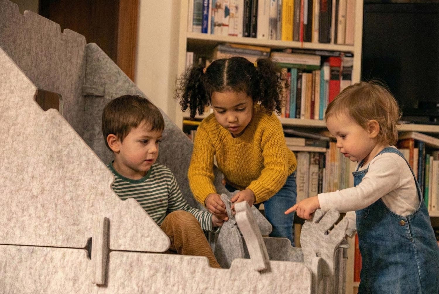 Kinder bauen gemeinsam ein Indoor-Spielhaus. Förderung der Kreativität, Teamwork und Motorik.